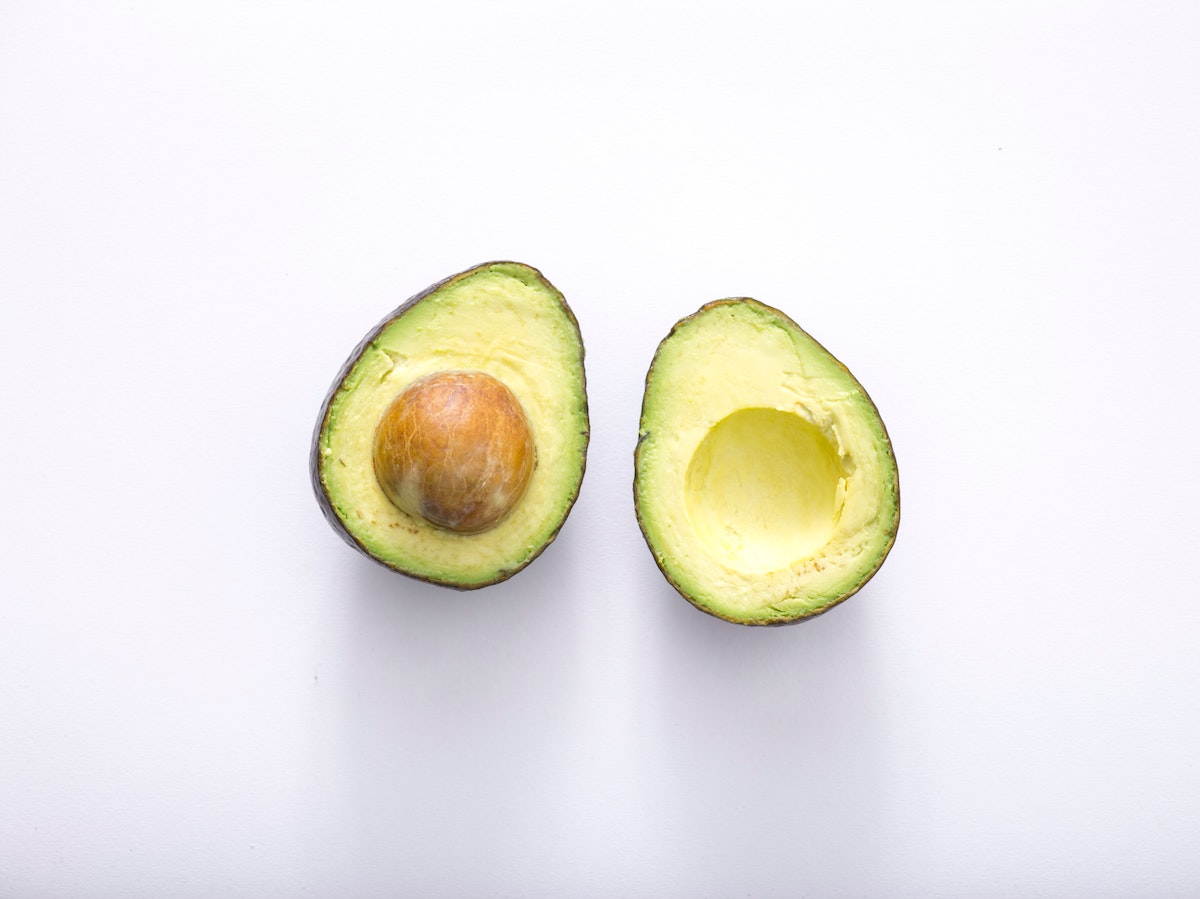 Avocado cut in half on white background