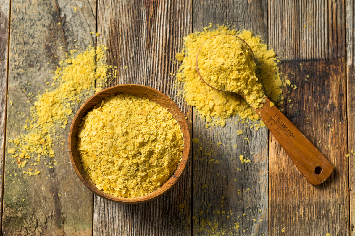 Yellow Organic Nutritional Yeast in a small wooden bowl