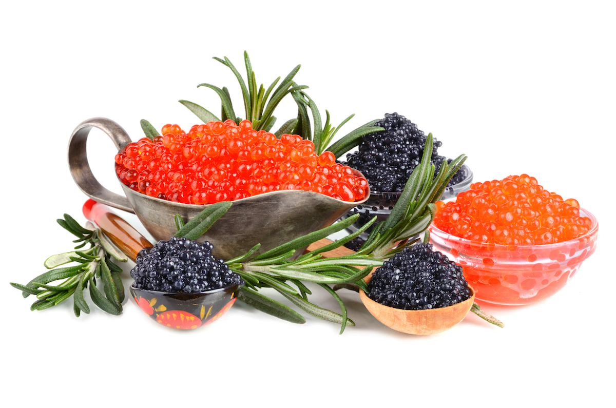 Black and red caviar (roe) in bowls on a white background