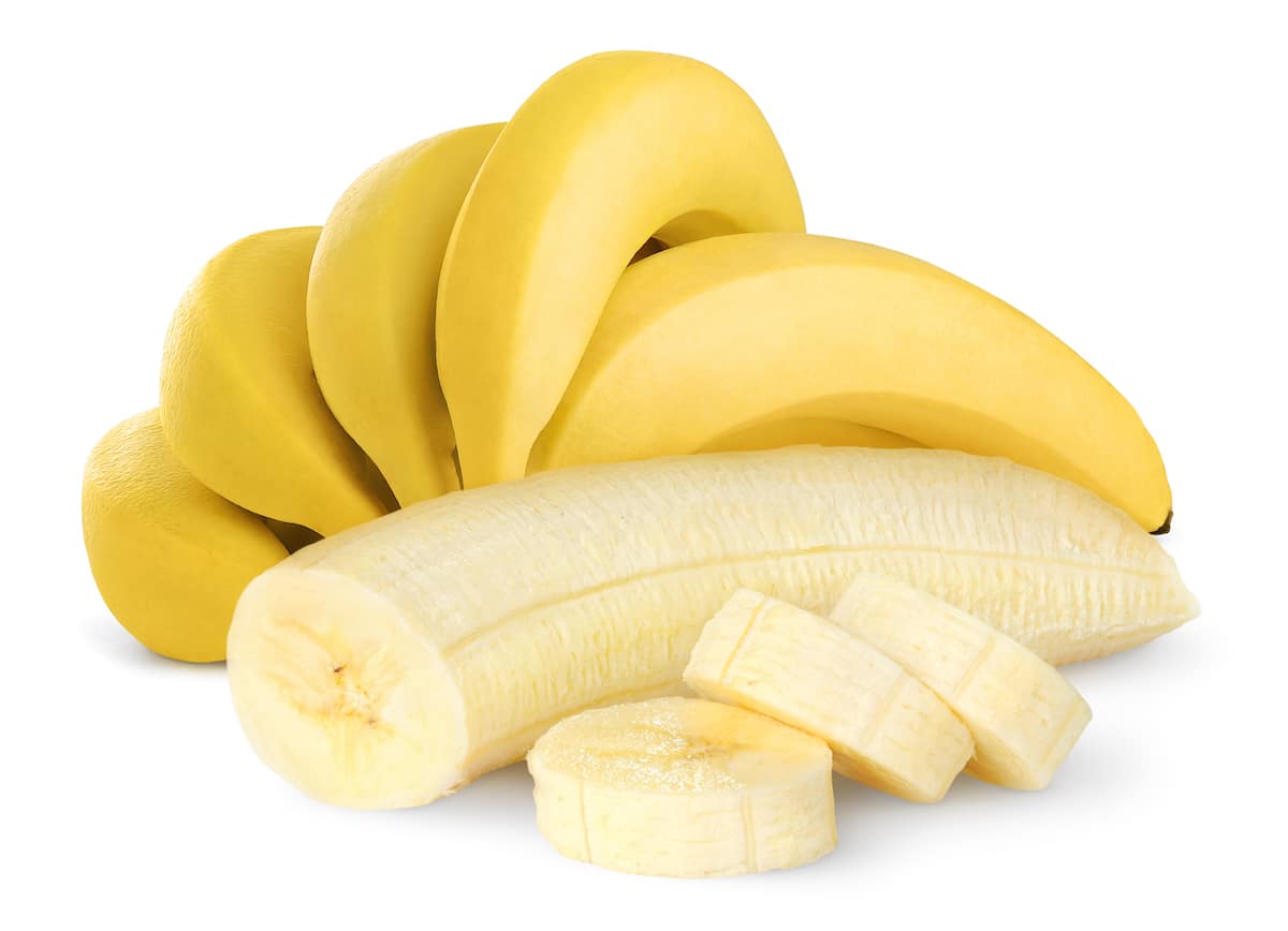 Bunch of yellow ripe bananas with one peeled banana in the foreground.