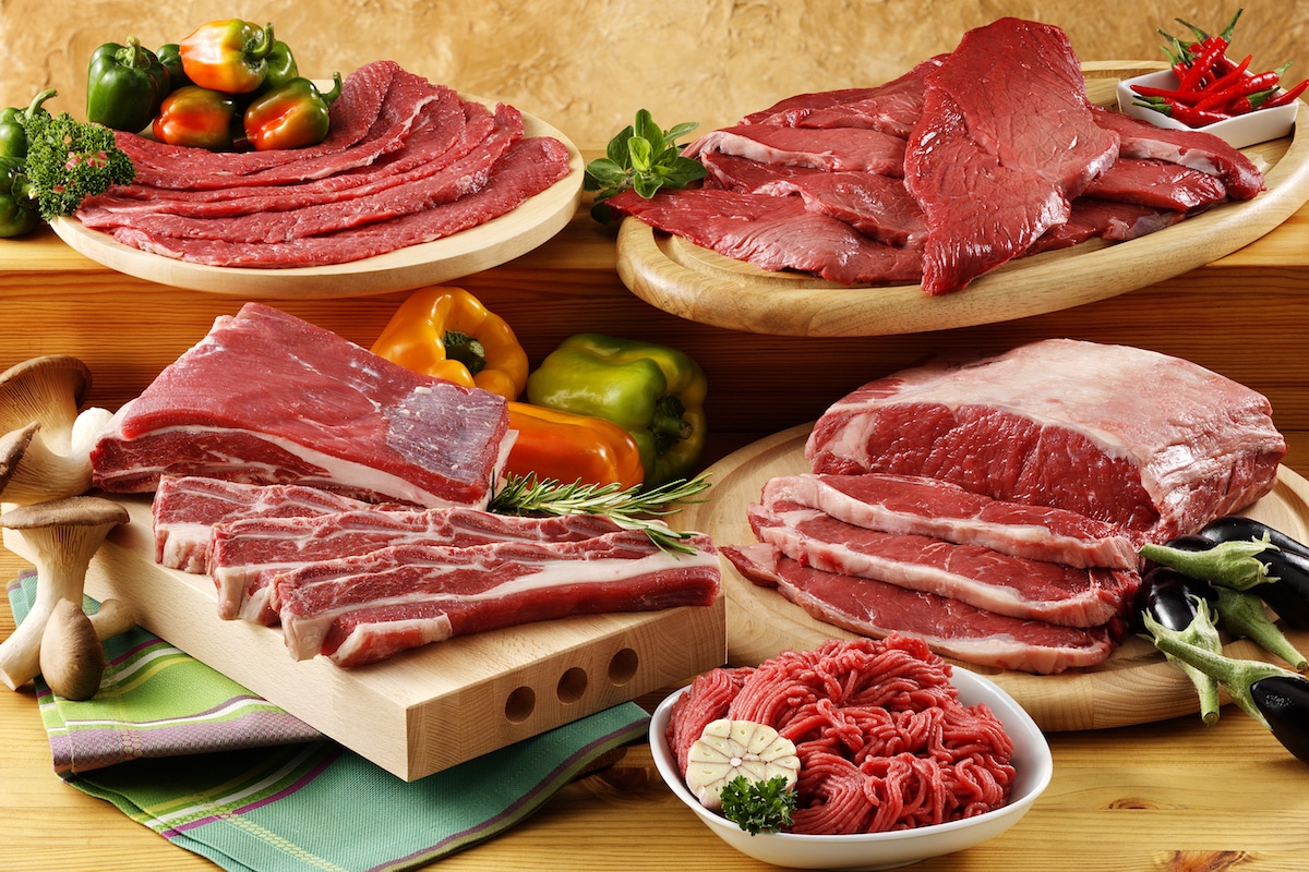 Selection of raw beef products, ground and whole, on wooden cutting boards.