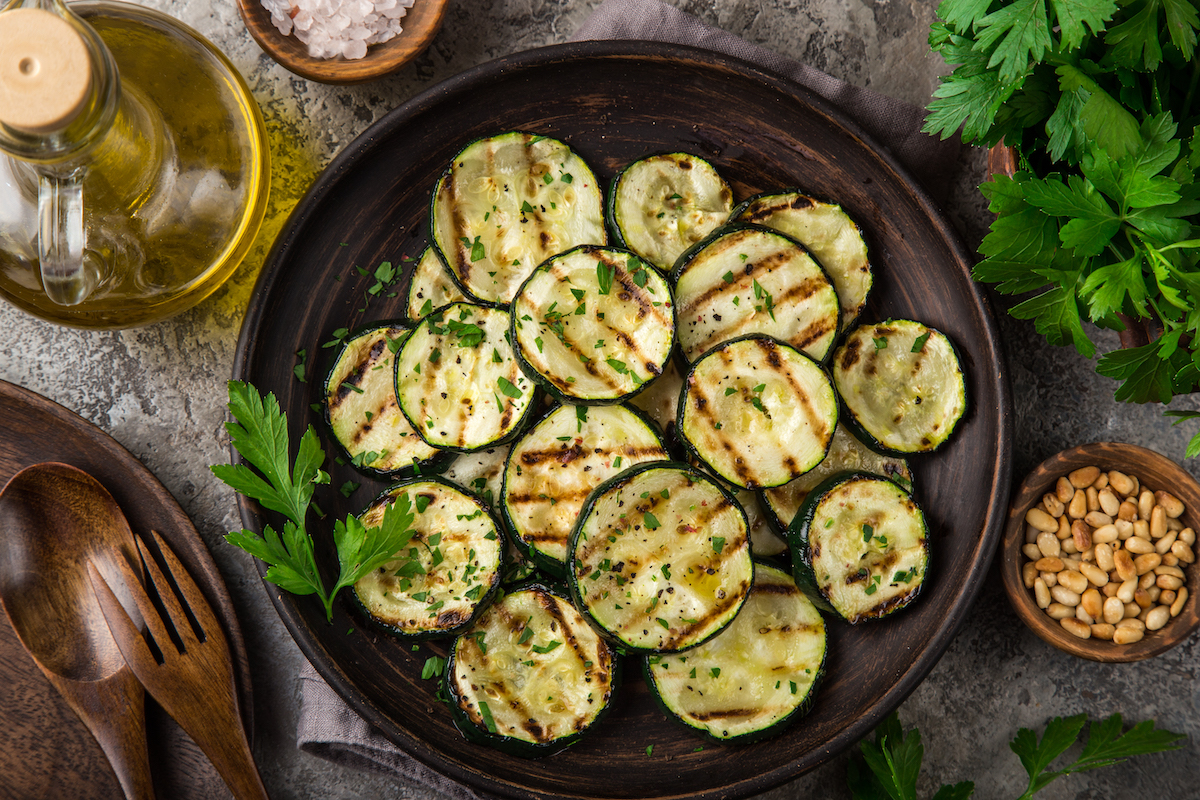 Grilled zucchini rounds on a dark round plate