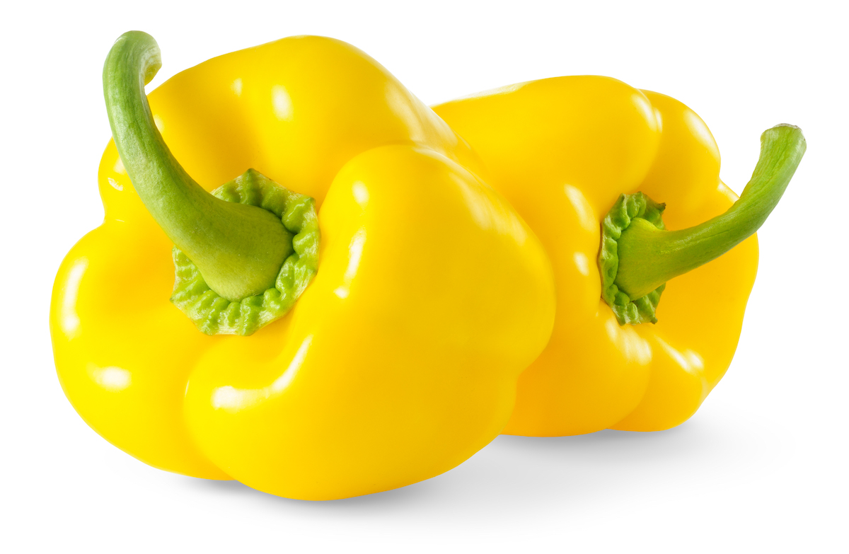 Two yellow bell peppers on a white background